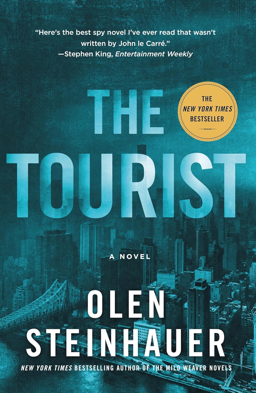 Book cover of 'The Tourist' by Olen Steinhauer with a cityscape background and New York Times Bestseller badge.